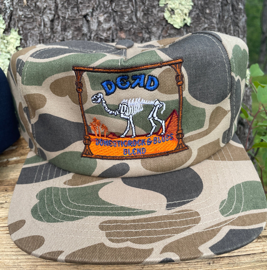 Camouflage-patterned product with a brand logo on a wooden surface