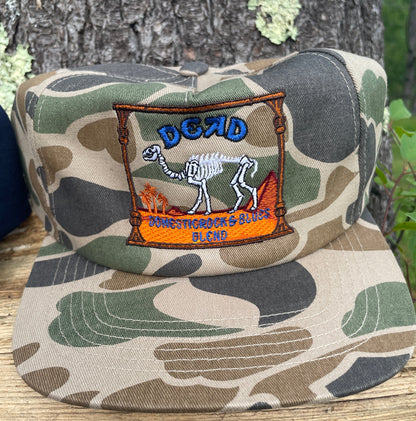 Camouflage-patterned product with a brand logo on a wooden surface